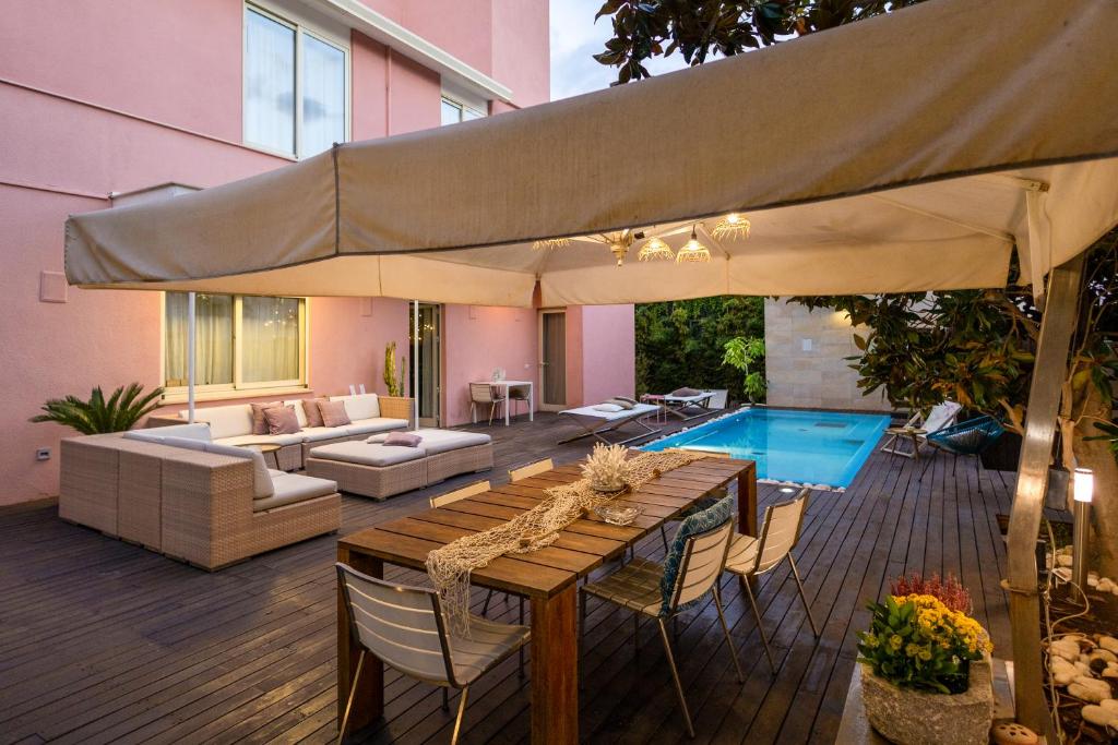 a patio with a table and a large umbrella at Villa Olimpia in Mondello