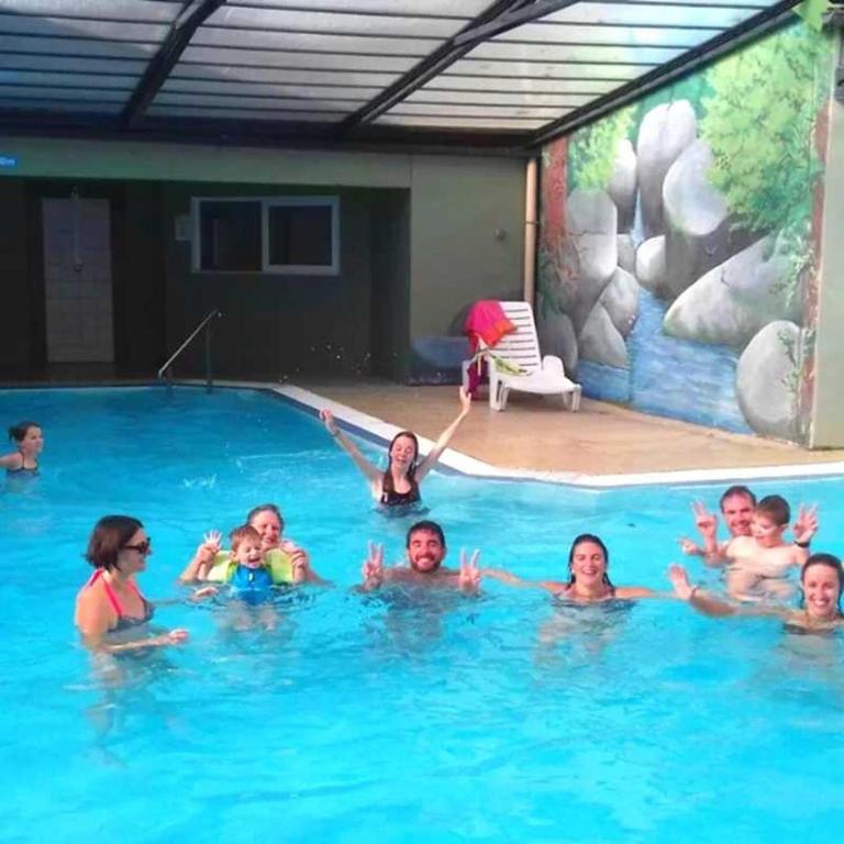 a group of people swimming in a swimming pool at ZEcamping 3 étoiles animaux acceptés piscine chauffée restaurant et soirées in Huelgoat