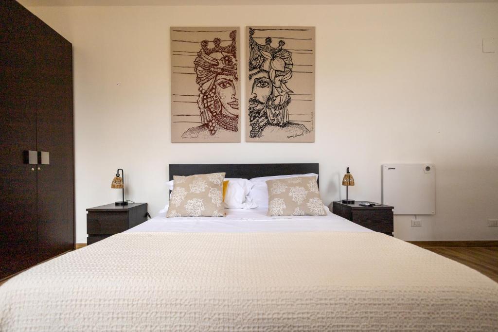 a bedroom with a large white bed with two night stands at Villa Olimpia in Mondello