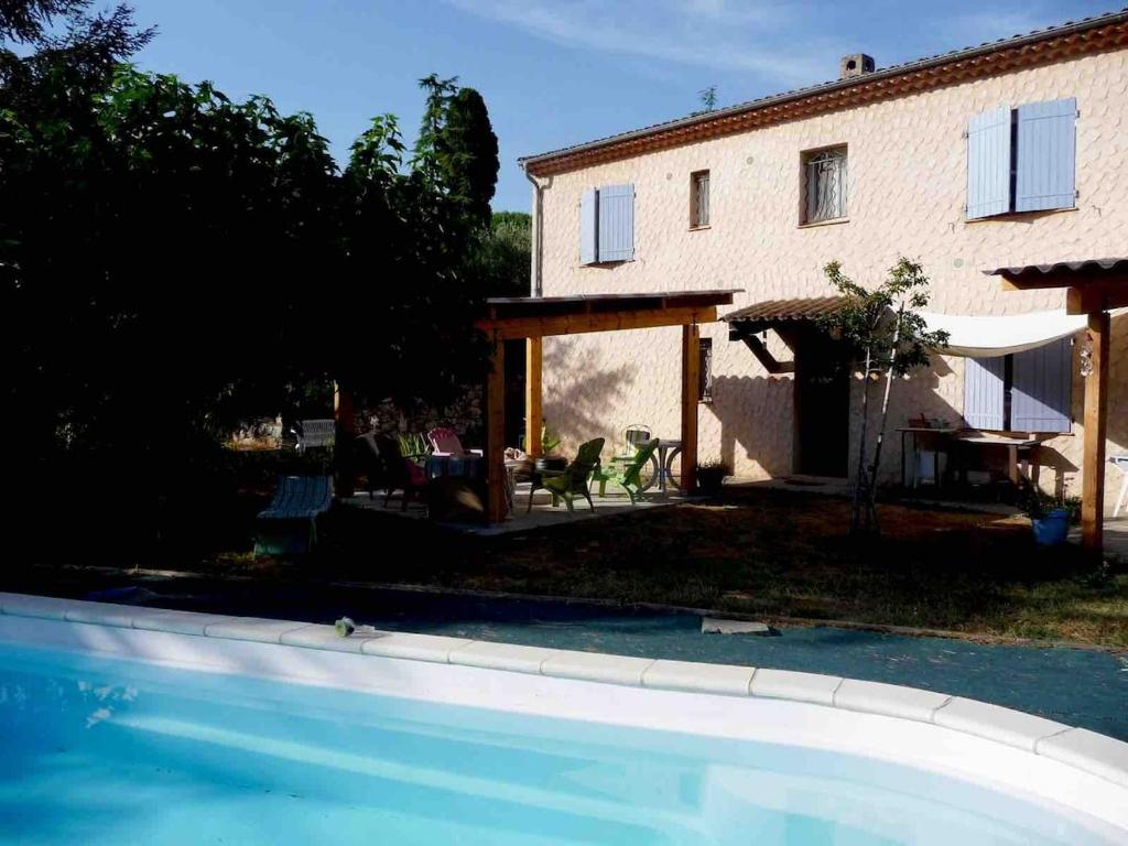 une arrière-cour avec une maison et une piscine dans l'établissement Appartement 3 pièces dans maison en rez-de-jardin, à Peymeinade