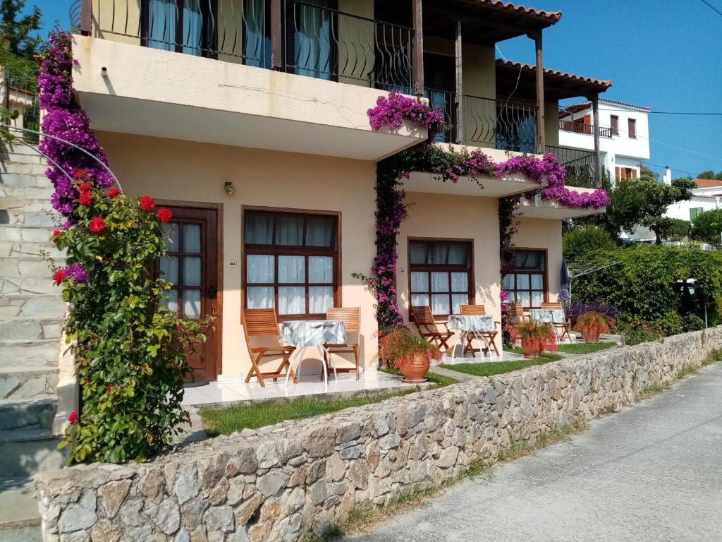 a building with flowers on the side of it at Dawn's Rooms in Patitiri
