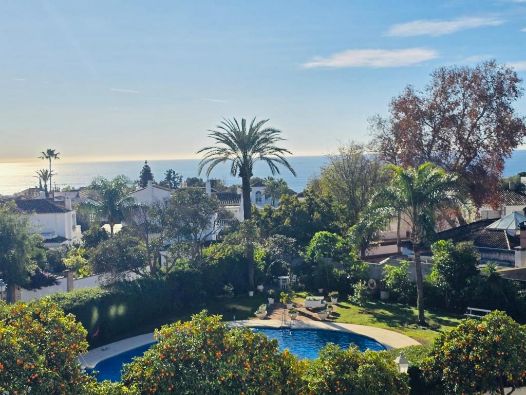 a view of a resort with a swimming pool and palm trees at Marbella city center appartment walking distance beach and plaza de los naranjos in Marbella
