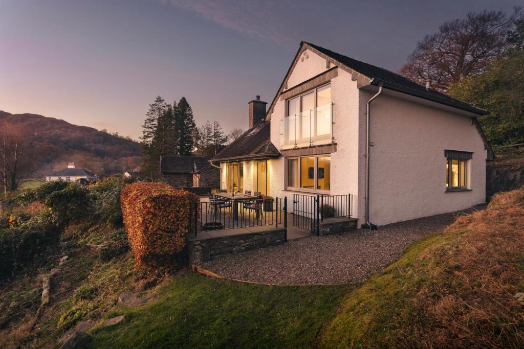 una casita blanca en una colina con una mesa en Barakat Lakes Escape, Ambleside, en Ambleside