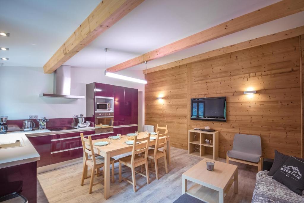 une cuisine et une salle à manger avec une table et des chaises dans l'établissement L'Ecrin du Val d'Arly - Vue montagne parking privé, à Flumet
