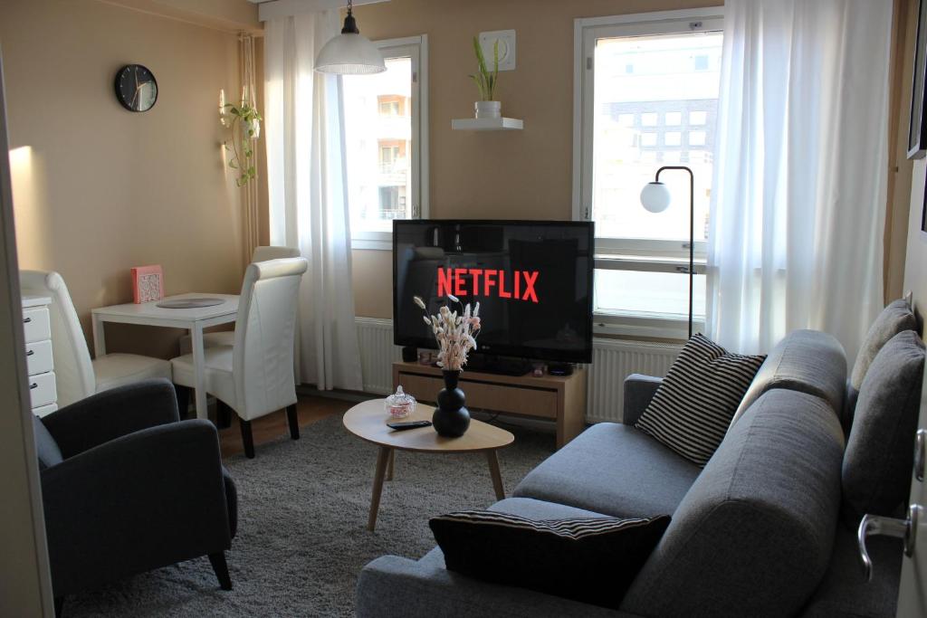 a living room with a couch and a tv at Two-room apartment in the center of Helsinki with a sauna! Free parking! in Helsinki
