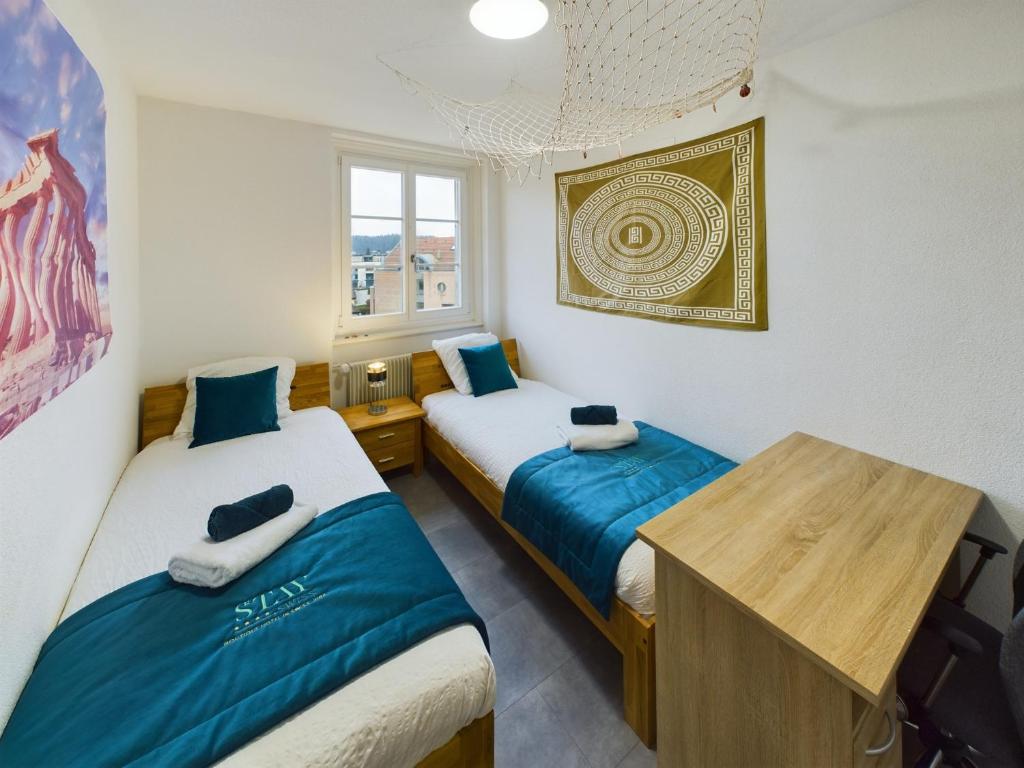 una camera con due letti e un tavolo in legno di The5Continents III - Youth Hostel by Stay Swiss a Porrentruy