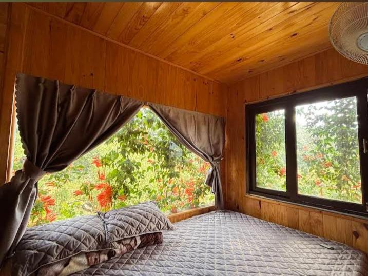 a bedroom with a bed in a room with a window at Chalet Bungalow Kala by Tâm Miên Man Homestay in Di Linh