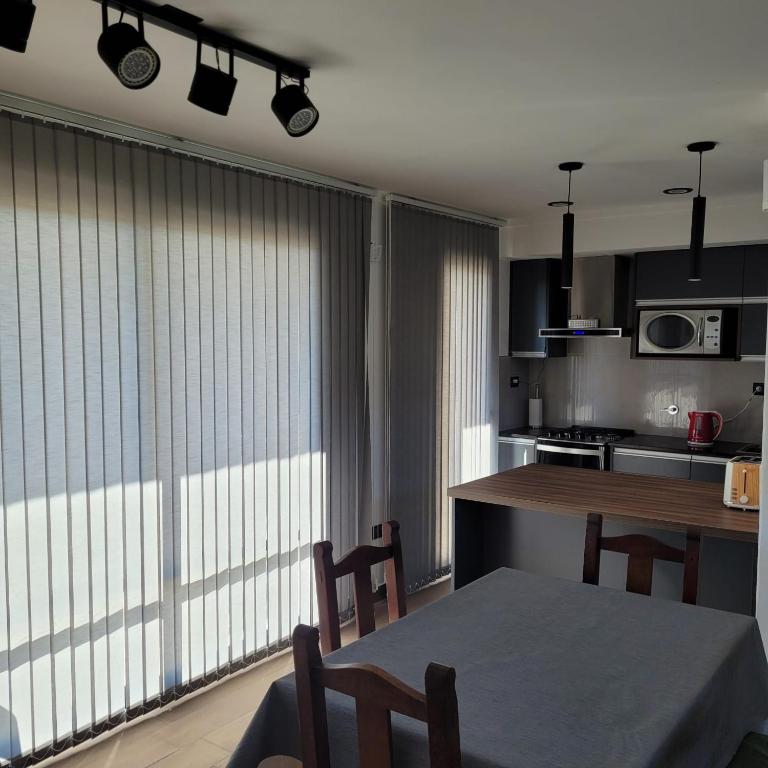 a kitchen with a table and a large window at Duplex a estrenar!! Zona Parque in Necochea