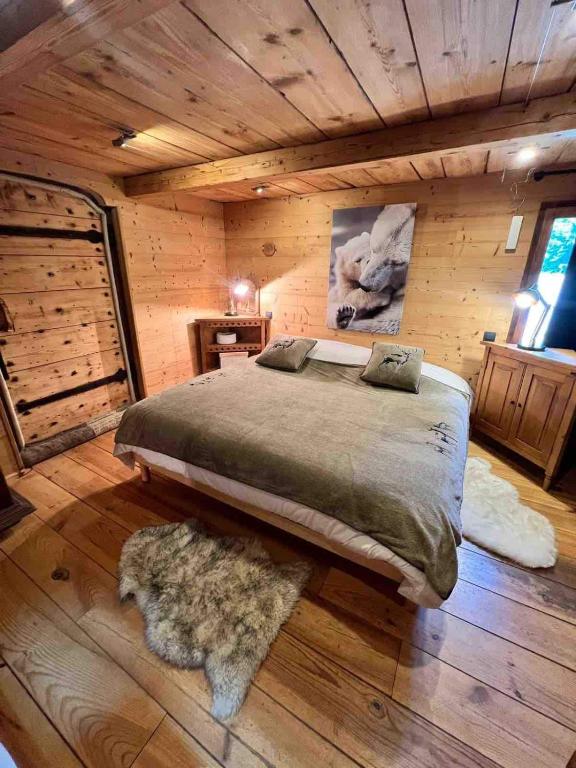 - une chambre avec un grand lit dans une cabane en rondins dans l'établissement Wood chalet -Poêle à bois - proche ski et télécabine, à Morillon