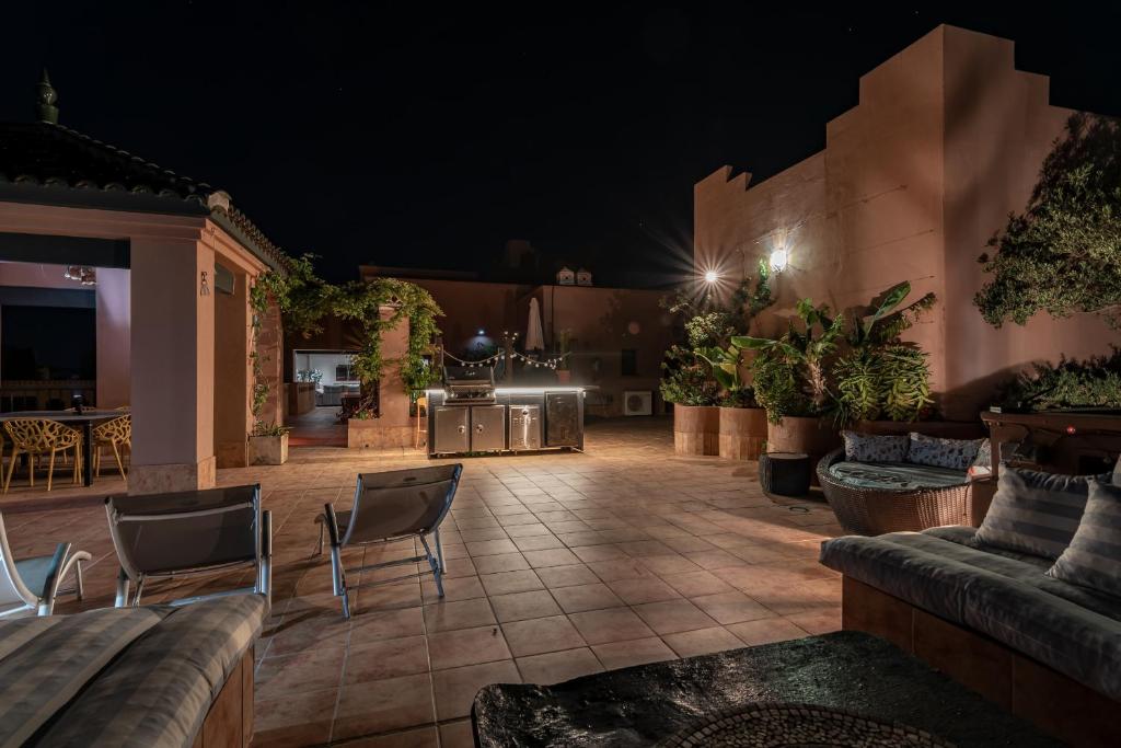 a patio at night with a couch and chairs at Playa Verde Atico by Ĥ - Playa Punta del Moral PPHV30P20 in Punta del moral