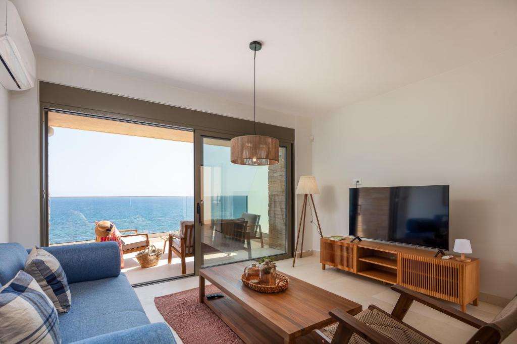 a living room with a blue couch and a tv at Kalyves Coastal Retreat in Chania Town