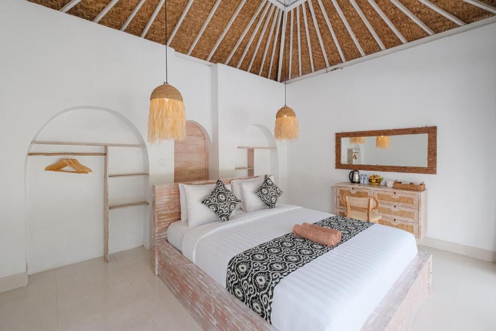 a white bedroom with a bed and a mirror at Bunbulan sunshine in Kubupenlokan