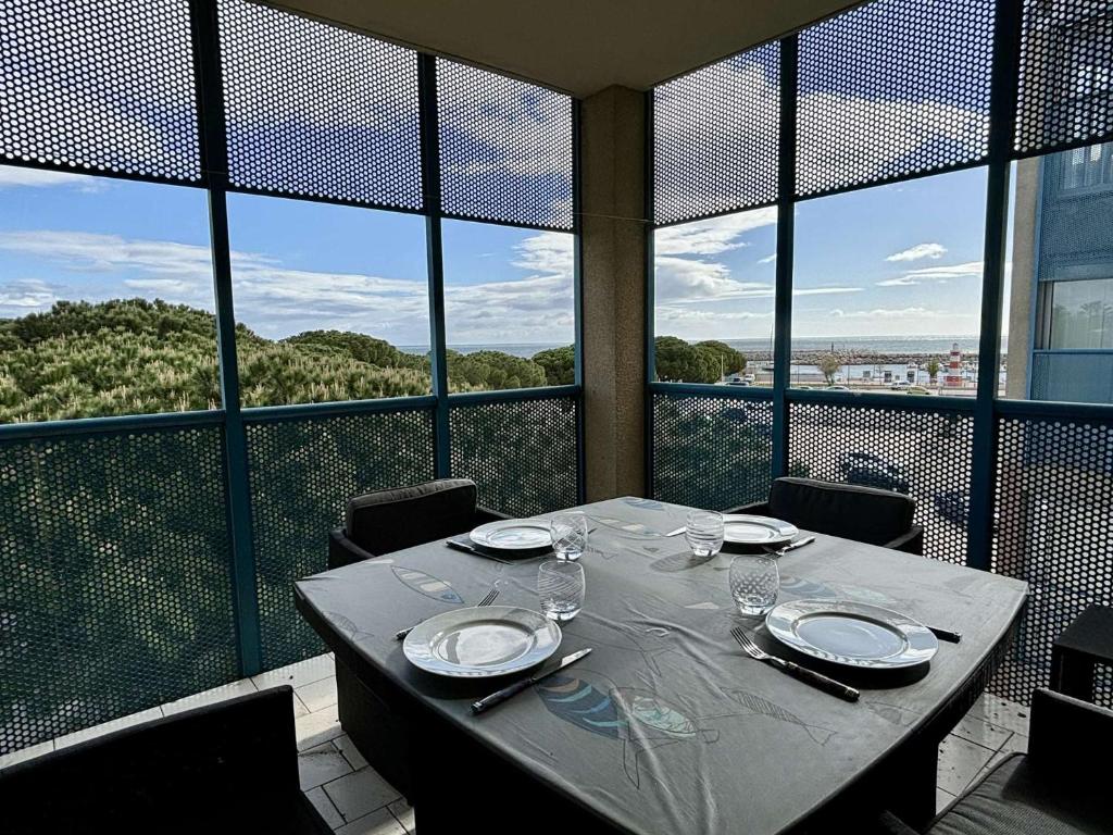 une table avec des assiettes et des verres à vin sur un balcon dans l'établissement Appartement 2 pièces 4 couchages ARGELES SUR MER AR250-302, à Argelès-sur-Mer