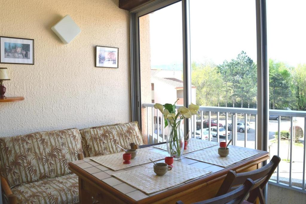 une table avec un vase de fleurs dessus dans l'établissement Appartement 2 pièces cabine 4 couchages ARGELES SUR MER AR460-130, à Argelès-sur-Mer