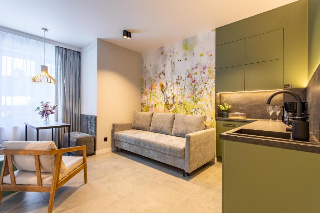 ein Wohnzimmer mit Sofa und eine Küche in der Unterkunft Apart-Invest Gimnazjalna 3 in Szklarska Poręba