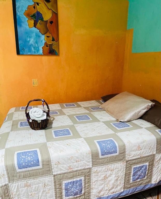 Una cama con una cesta encima. en Posada Maná, en San Juan La Laguna