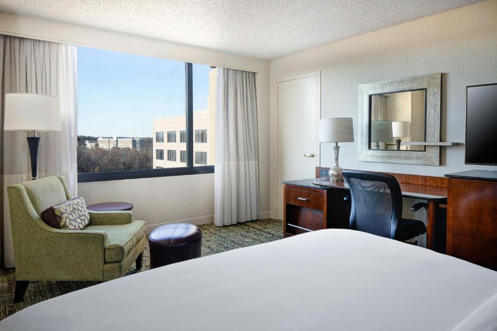 a hotel room with a bed and a large window at Marriott St. Louis West in Chesterfield