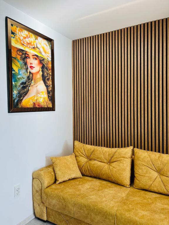 a couch in a room with a painting on the wall at Gold House in Bucharest