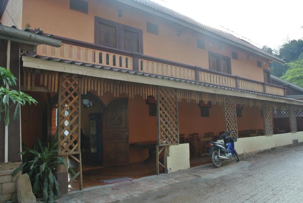 a motorcycle parked in front of a building at BKC villa in Pakbeng