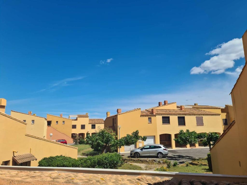 une voiture garée dans un parking en face des bâtiments dans l'établissement Appartement 2 pièces CAP D'AGDE CT230-026, au Cap d'Agde