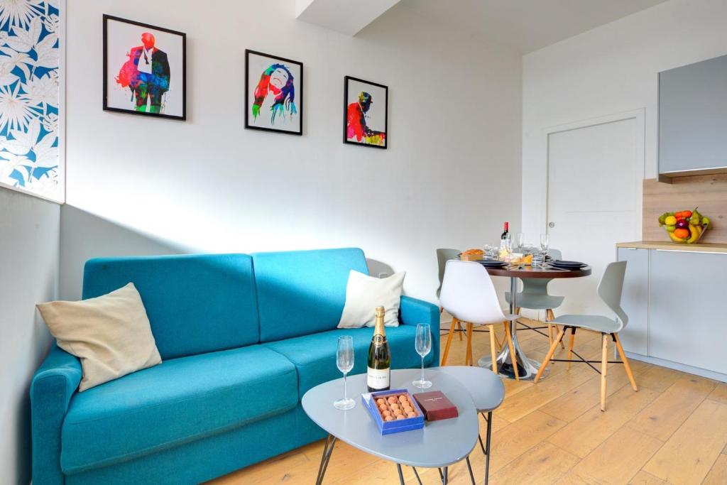 un salon avec un canapé bleu et une table dans l'établissement Bluestay 48 - Superb apartment in Paris, à Paris