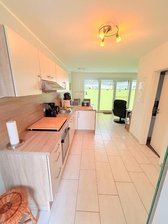 a kitchen with white cabinets and a tile floor at Natur und Meer in Graal-Müritz