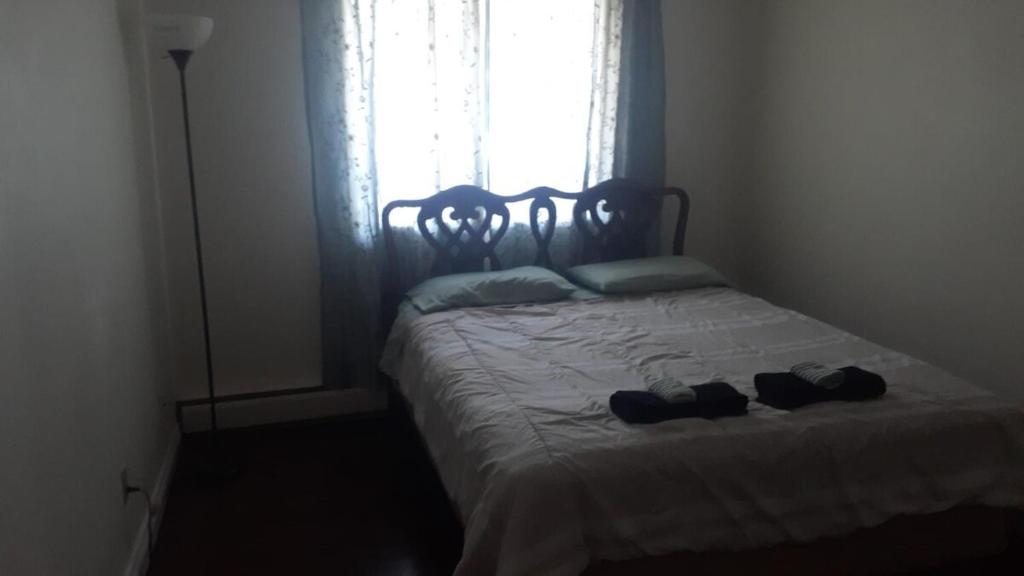 Una cama con dos pares de zapatos encima en Cozy & bright private one-bed rm, en Edmonton