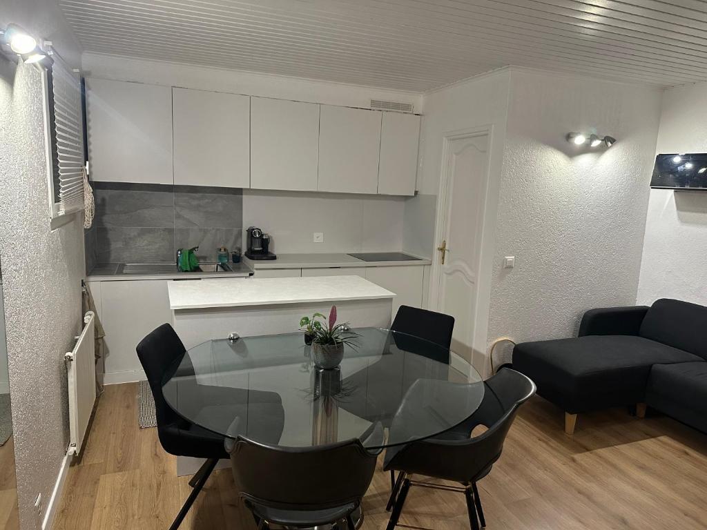 a kitchen and a dining room with a glass table at Les terrasses de Valère in Sion
