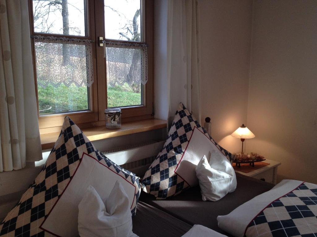 Zimmer mit einem Bett, zwei Fenstern und einem Sofa in der Unterkunft Ferienwohnung Familie Kitzke in Teisnach