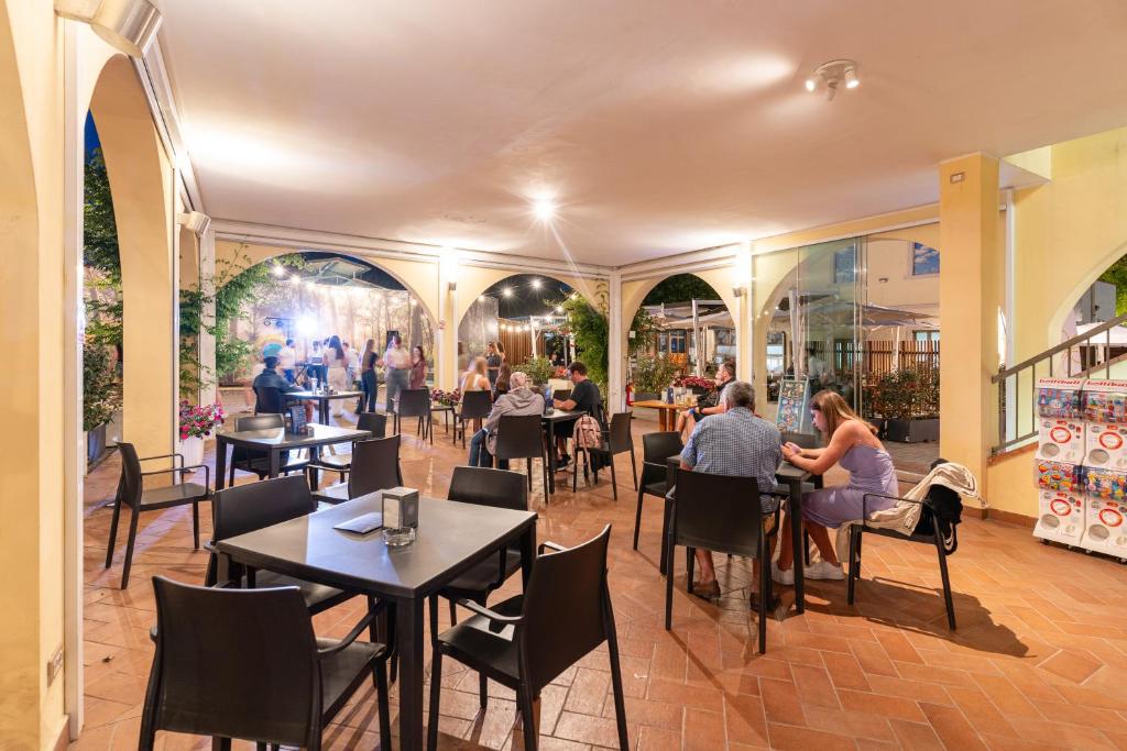 a restaurant with tables and people sitting at tables at Club del Sole Viareggio Family Collection in Torre del Lago Puccini