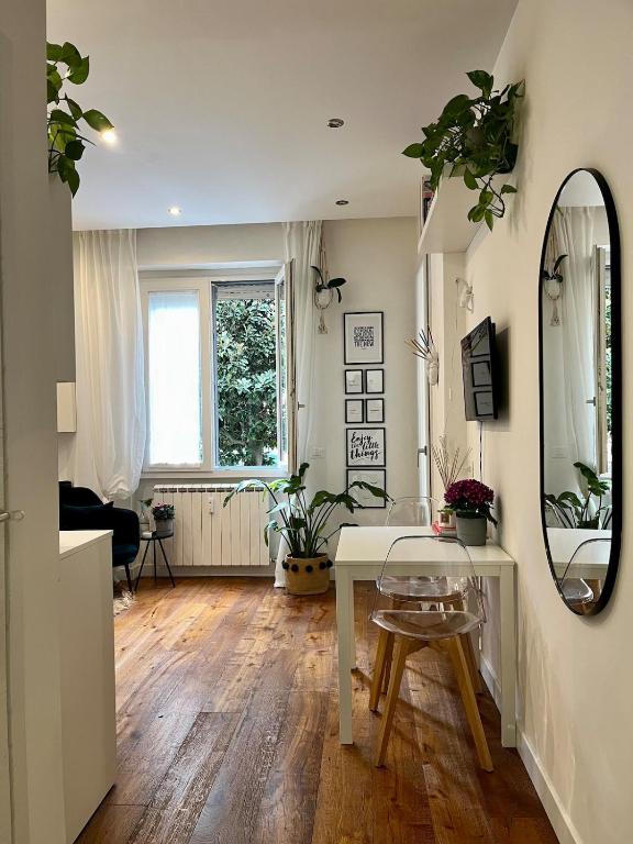 ein Wohnzimmer mit einem Tisch und einem Spiegel in der Unterkunft Magnolia 84 Apartment in Florenz