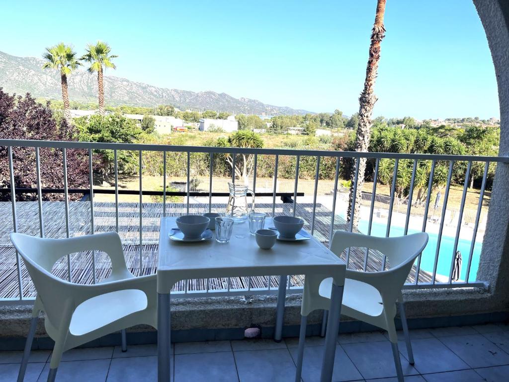 une table et des chaises sur un balcon avec vue dans l'établissement Studio avec piscine SAINT FLORENT - FLO300-134, à Saint-Florent