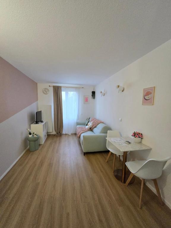un salon avec un canapé et une table dans l'établissement Le Studio Pastel, à Bussy-Saint-Georges