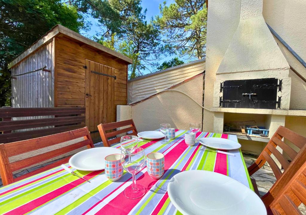 une table avec des assiettes et des verres au-dessus dans l'établissement SYLVICULTEURS - Charmante villa patio rénovée, à Seignosse