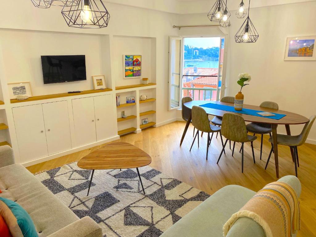 un salon avec une table et une télévision dans l'établissement LARA AP4441 By Riviera Holiday Homes, à Villefranche-sur-Mer