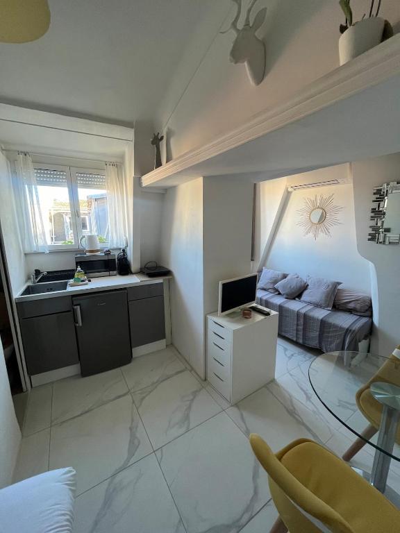 un petit salon avec un canapé et une cuisine dans l'établissement Gounod - Studio cosy dans le centre de Nice, à Nice