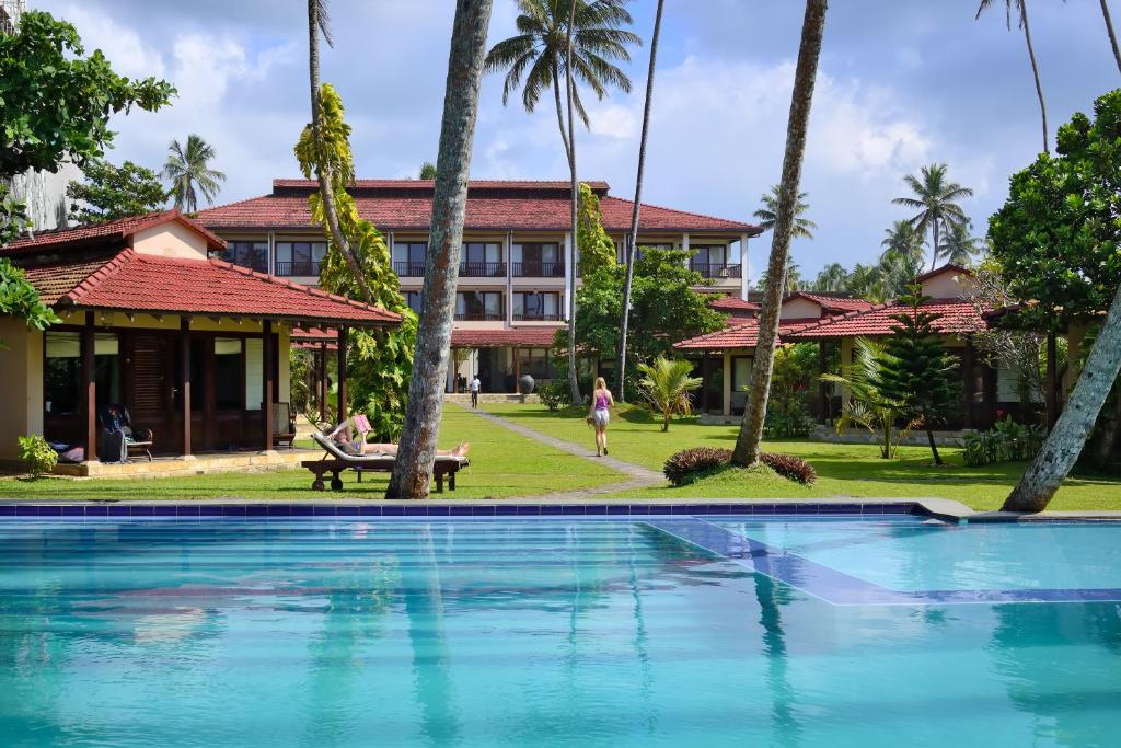 a swimming pool in front of a resort at Weligama Bay Resort in Weligama
