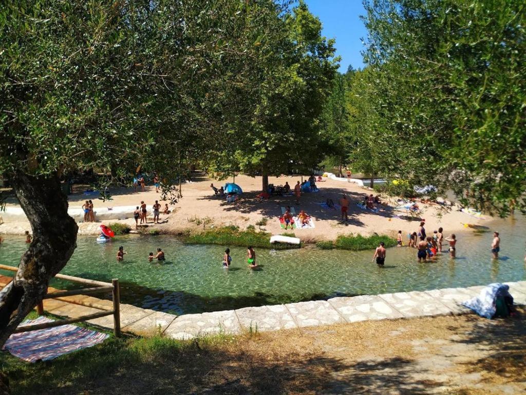 a group of people in the water at a beach at Olhos d' Água in Alcanena