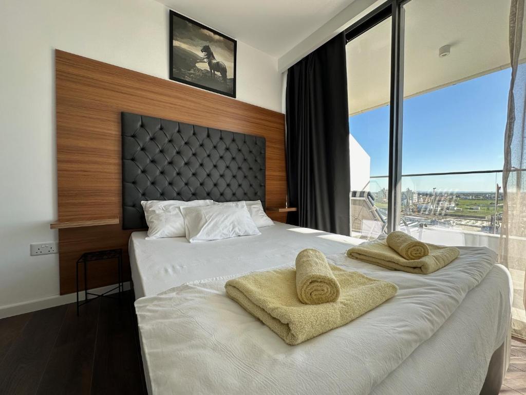 Un dormitorio con una cama grande con dos toallas encima. en Grand Sapphire Deluxe Residances, en Saint Yeorgios