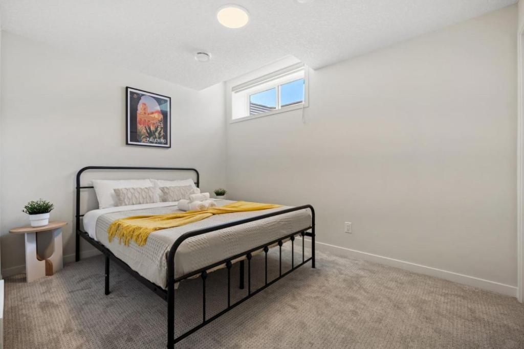 a bedroom with a bed with a yellow blanket on it at Private Lower Suite, Sleeps 4, Queen Bed, Netflix, Parking in Balzac