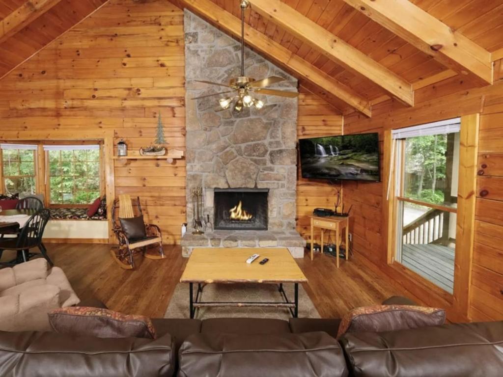 a living room with a fireplace in a log cabin at Country Romance - Peaceful Getaway in Jones Cove