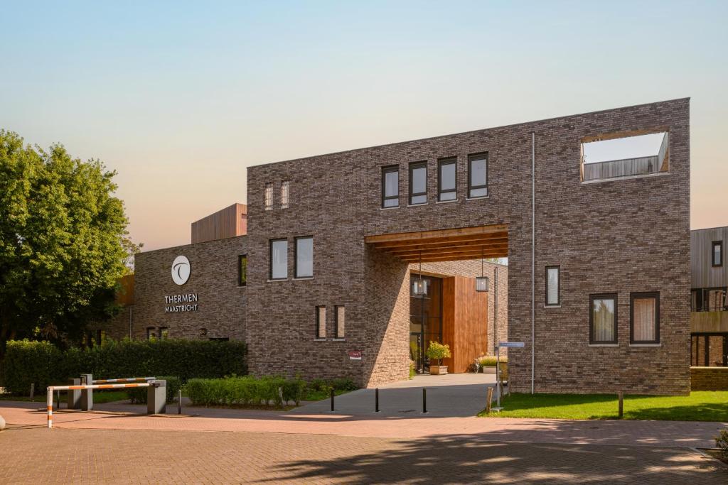 a brick building with an archway in front of it at Dormio Resort Maastricht Castellum Apartments in Maastricht