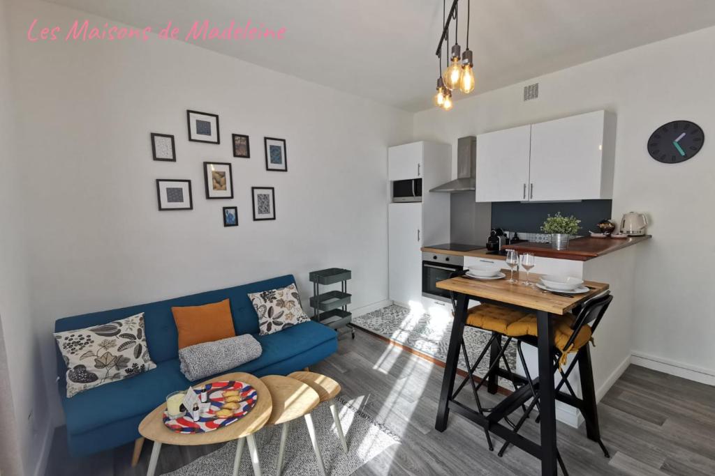 un salon avec un canapé bleu et une cuisine dans l'établissement Nouveau - Sarrazin, à Nantes