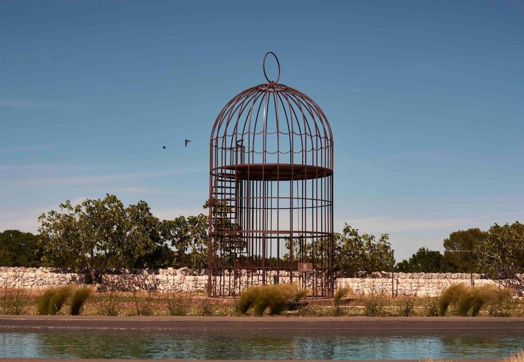 a bird cage sitting next to a body of water at Trulli Mansueto in Noci