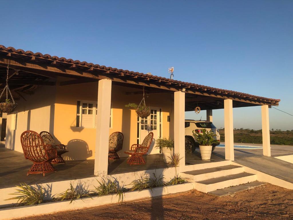 a porch of a house with chairs and a truck at Casa Doce Morada in Piranhas
