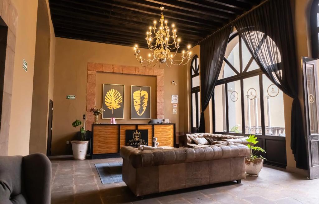 a living room with a couch and a chandelier at Hotel Plaza de Armas in Querétaro