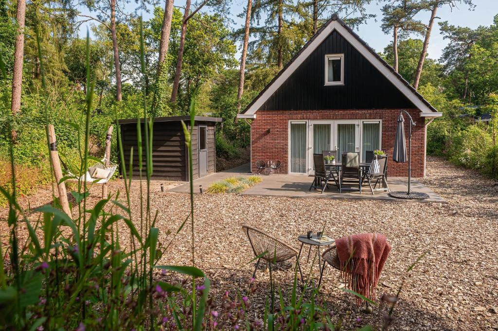 een klein huisje midden in een tuin bij Luxe Vakantiehuis Koekoek Veluwe in Nunspeet