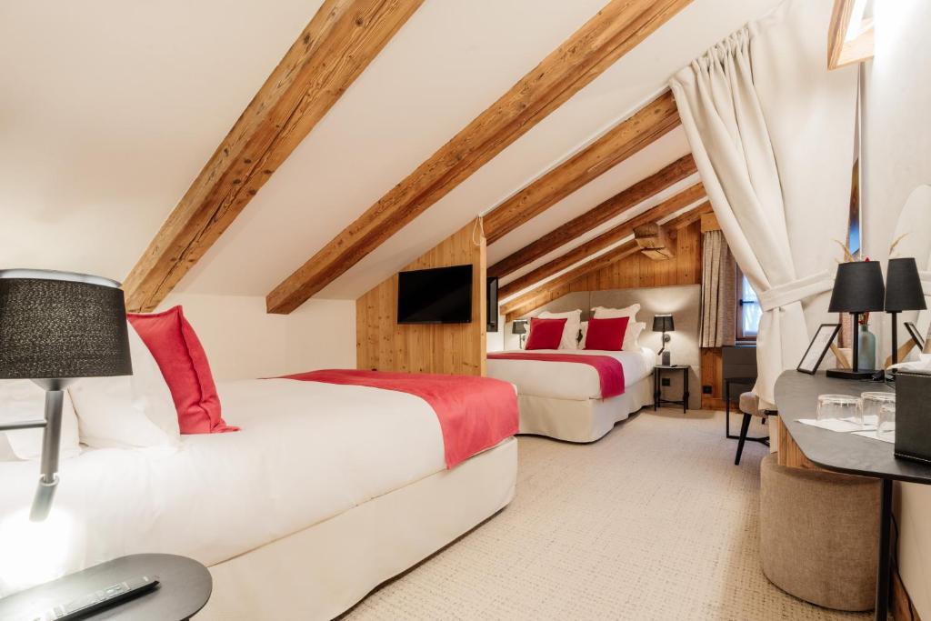 a bedroom with two beds and a desk at La Ferme du Golf in Megève