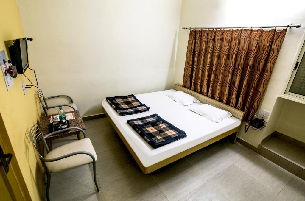a small room with a bed and a chair at Hotel Akashdeep in Rānchī