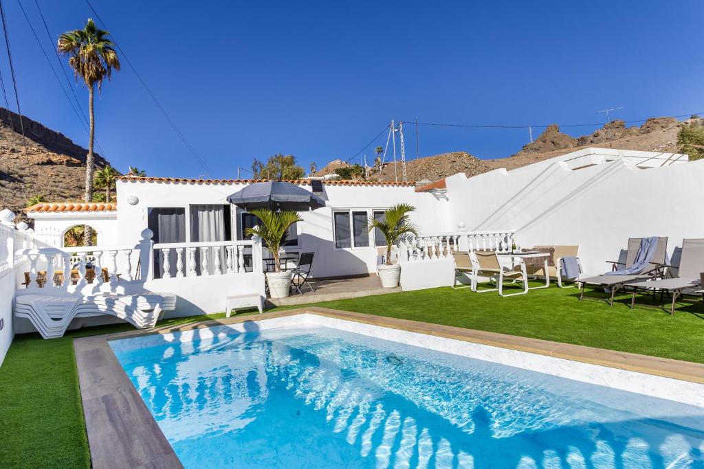 a villa with a swimming pool and a yard at House of dreams in Mogán
